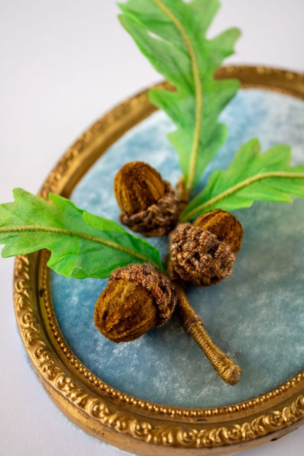 An acorn cap stitched with a woven Brussels Stitch, using a wool-silk blend thread and tapestry needle